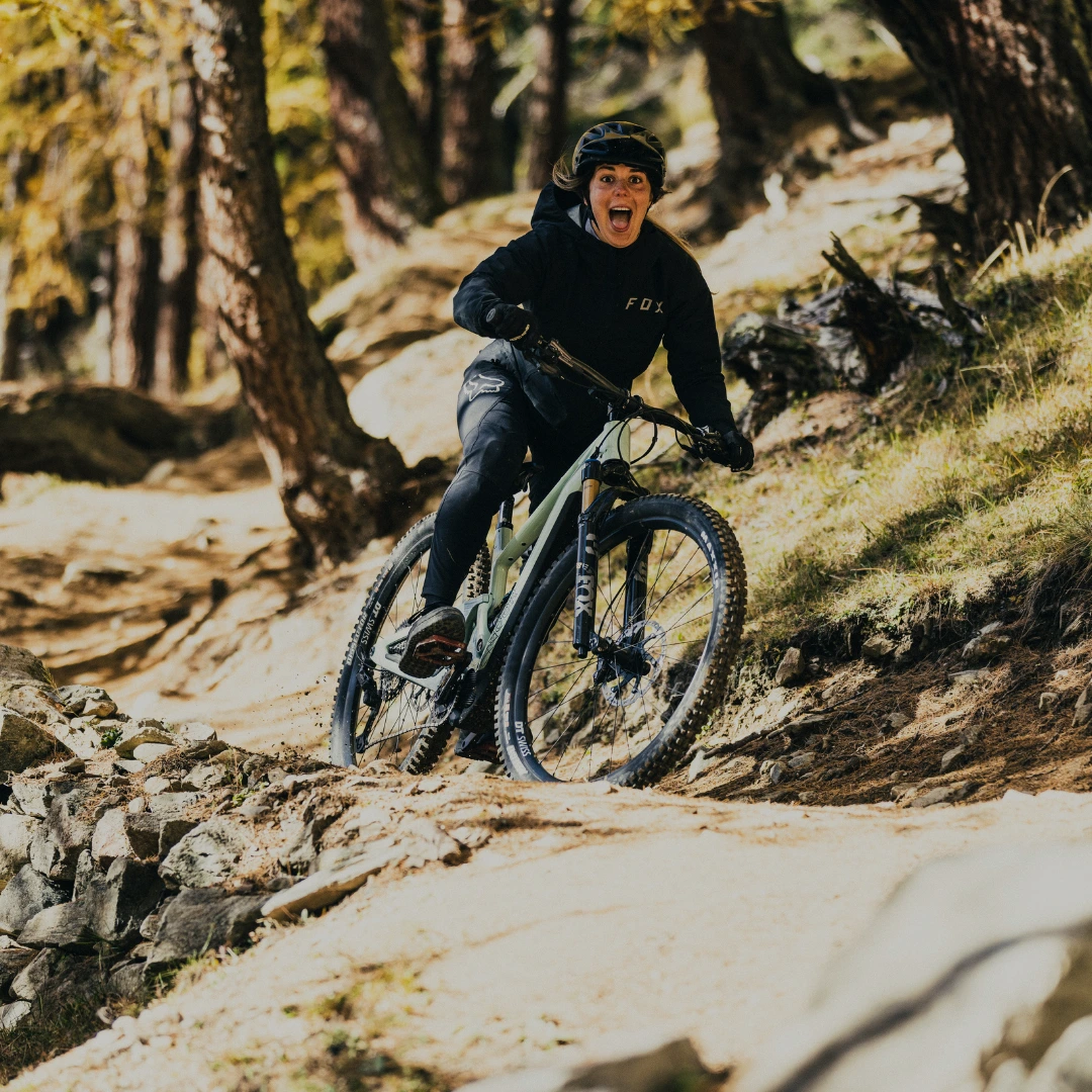 SCOR E-Fully´s Fahrer meistert eine Holzbrücke auf einem Trail durch den herbstlichen Wald.
