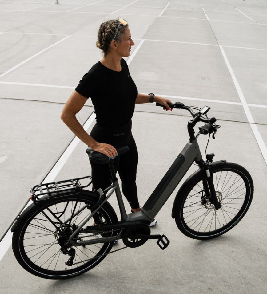 Radfahrerin hält ihr Fahrrad auf Parkplatz