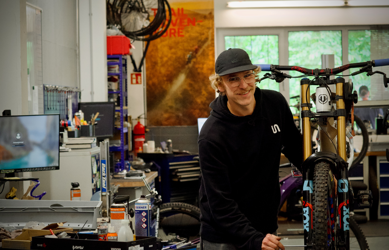 Mechaniker in der Werkstatt schraubt an Downhill Bike