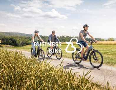 Business Bike Logo auf Hintergrund mit Gruppe Trekkingbike Fahrern bei sonnigem Wetter